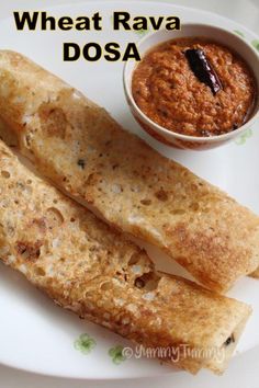 some food on a white plate with a small bowl of sauce next to it and the words wheat ravia dosa