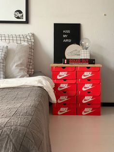 a bed room with a neatly made bed and two red boxes on the nightstands