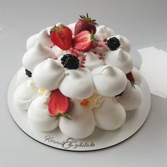 a white cake topped with whipped cream and strawberries