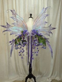 a white mannequin with purple and green flowers on it