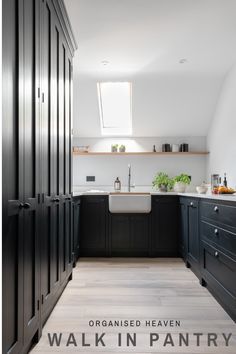 an open kitchen with black cabinets and white counter tops is seen from the hallway to the dining room