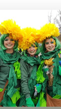 three women dressed in green and yellow with flowers on their heads