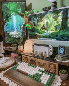 a computer keyboard sitting on top of a wooden desk in front of a tv screen