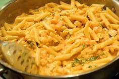 a pan filled with pasta and sauce on top of a stove