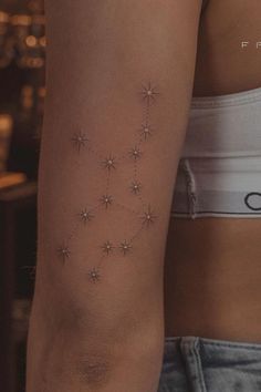 a woman's arm with small stars on it