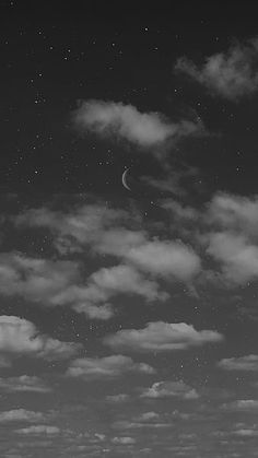 black and white photograph of the moon in the night sky with stars above it, as seen from an open field