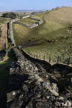 a stone wall in the middle of a field