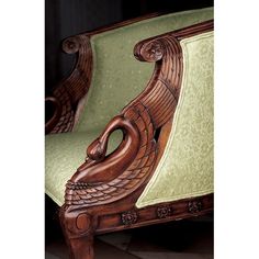 an ornate wooden chair with green upholstered fabric