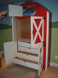 a child's bedroom with a red and white barn - style cabinet in the corner