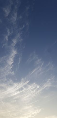 the airplane is flying high in the sky with some clouds on it's back