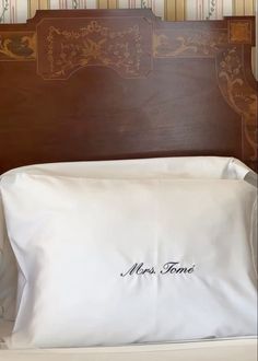 there is a pillow with the name miss jones on it in front of a wooden headboard