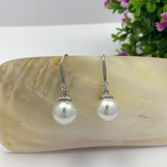 Experience elegance with our White Pearl Dangle Drop Earrings for Women! These stunning earrings feature lustrous white pearls that hang delicately from your ears, adding a touch of sophistication to any outfit. Treat yourself or a loved one to a timeless piece that exudes luxury and beauty. Material: Alloy/Pearl/Cubic Zirconia Earrings Size: 1.2"x0.4" White Pearl Dangling Earrings For Party, White Feminine Dangle Pearl Earrings, Elegant White Long Drop Pearl Earrings, Hypoallergenic Pearl White Dangle Earrings, Pearl White Dangle Earrings, Feminine Style, Cubic Zirconia Earrings, Zirconia Earrings, Stunning Earrings, White Pearl