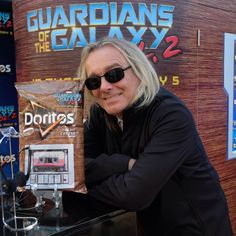 a man with sunglasses on holding up a radio set in front of a display case