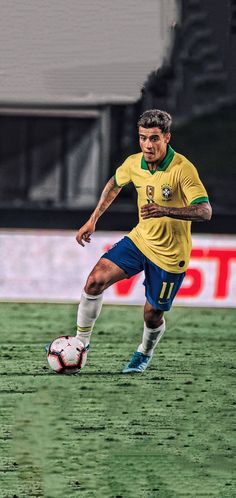 a soccer player is running with the ball in his hand as he prepares to kick it