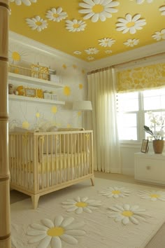 a baby's room decorated in yellow and white with flowers painted on the ceiling