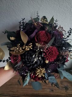 a bouquet of flowers sitting on top of a wooden table