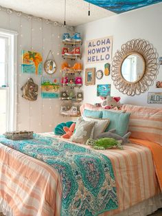 a bedroom decorated in pastel colors with an orange, blue and white bed spread