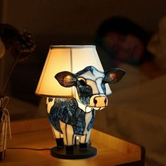 a cow lamp sitting on top of a wooden table