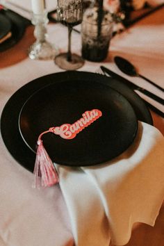 a black plate sitting on top of a table next to silverware and utensils