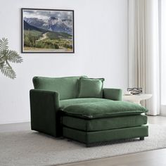 a living room with a green couch and chair in front of a painting on the wall