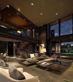 a living room filled with lots of furniture next to large windows and a fire place