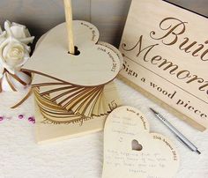 two wooden heart shaped boxes with writing on them and a pen next to one that says,'best mom in a wood box '