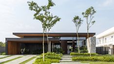 a modern house with grass and trees in the front yard