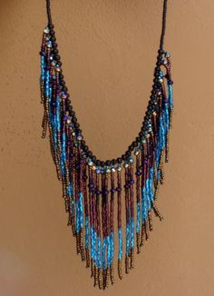 "Fringe Necklace, Seed Bead Necklace, Handmade Bohemian Blue Black Bib Necklace This stunning easy to wear necklace, with a magnetic closure, is a glamorous accessory that will be sure to flatter your neck. Handcrafted with beautiful blue, purple, black, and bronze colored beads into a fringe necklace. This is that chic accessory that will enhance your casual or dressy wardrobe. Necklace measures 19 1/4\" from end to end (magnetic closure) Fringe Length: Longest 3 1/4\" Shortest 1 7/8\" Weight: Basket Weaving Patterns, Wear Necklaces, Fringe Necklace, Seed Bead Necklace, Jewelry Boho, Weaving Patterns, Beaded Fringe, Chic Accessories, Bib Necklace