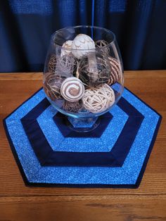 a glass bowl filled with assorted items on top of a blue place mat