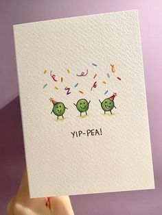 a hand holding up a card with two green birds on it that says yip - pea