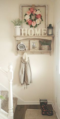 there is a coat rack on the wall with flowers in it and a welcome home sign above