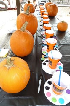 there are many pumpkins on the table with cups and saucers next to them