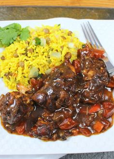 slow cooker jamaican brown stew chicken with rice and cilantro on the side