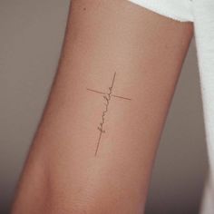 a woman's arm with a cross tattoo on the left side of her arm