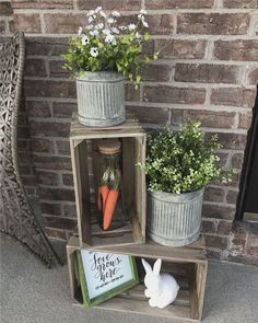 three wooden crates with carrots and flowers in them