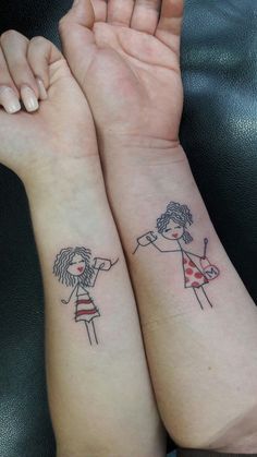 two girls with matching tattoos on their arms, one is holding her hand up to the other