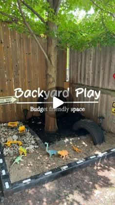 an outdoor play area with toys in the dirt and wooden fence behind it that says backyard play