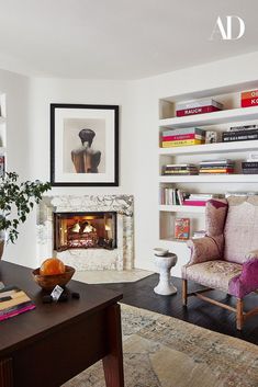 a living room filled with furniture and a fire place next to a bookshelf