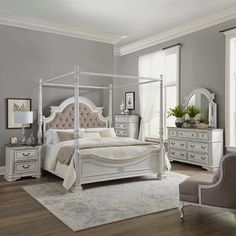 a white bed sitting in a bedroom on top of a hard wood floor