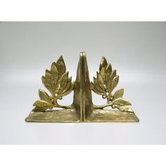 a pair of brass bookends with leaves on them