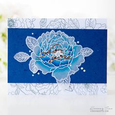 a blue and white card with a flower on it