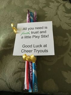 some candy sticks are on top of a sign that says, all you need is faith, trust and a little pixy six good luck at cheer tryouts