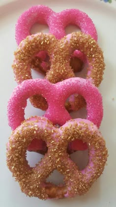 pink and gold donuts with sprinkles on a white plate