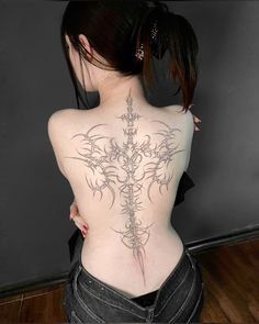 the back of a woman's body with tattoos on her upper and lower back