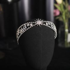 a tiara on a mannequin with flowers in the background