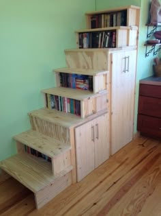 there is a set of stairs made out of wood and has bookshelves on each side