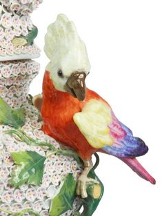 a figurine of a bird sitting on top of a flowered tree branch