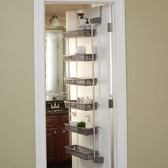 the door is open to reveal a shelf with baskets and other items on it in a bathroom