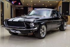 an old black mustang sitting in a showroom