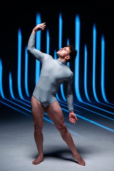 a man in a gray bodysuit is stretching